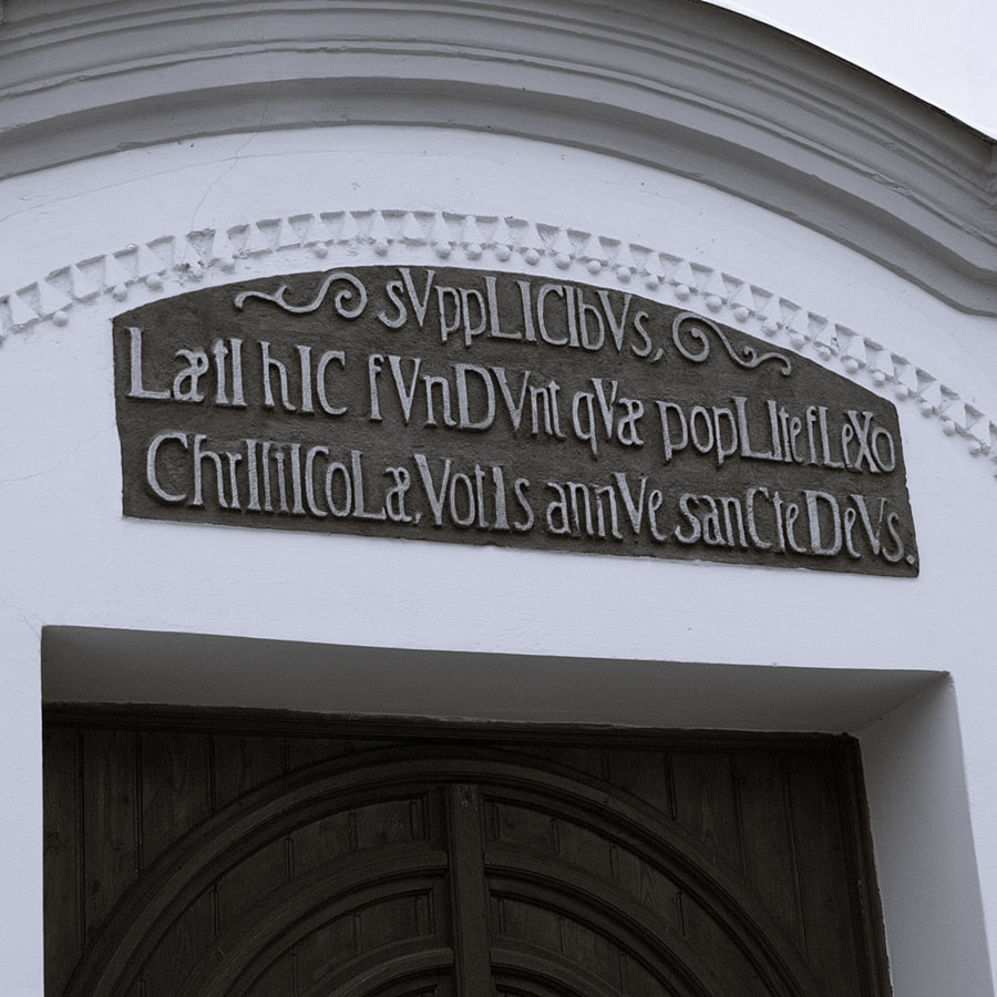Picture,Latinský nápis nad vchodom. V kostole sú nápisy v troch jazykoch - latinčine, biblickej češtine a v nemčine.